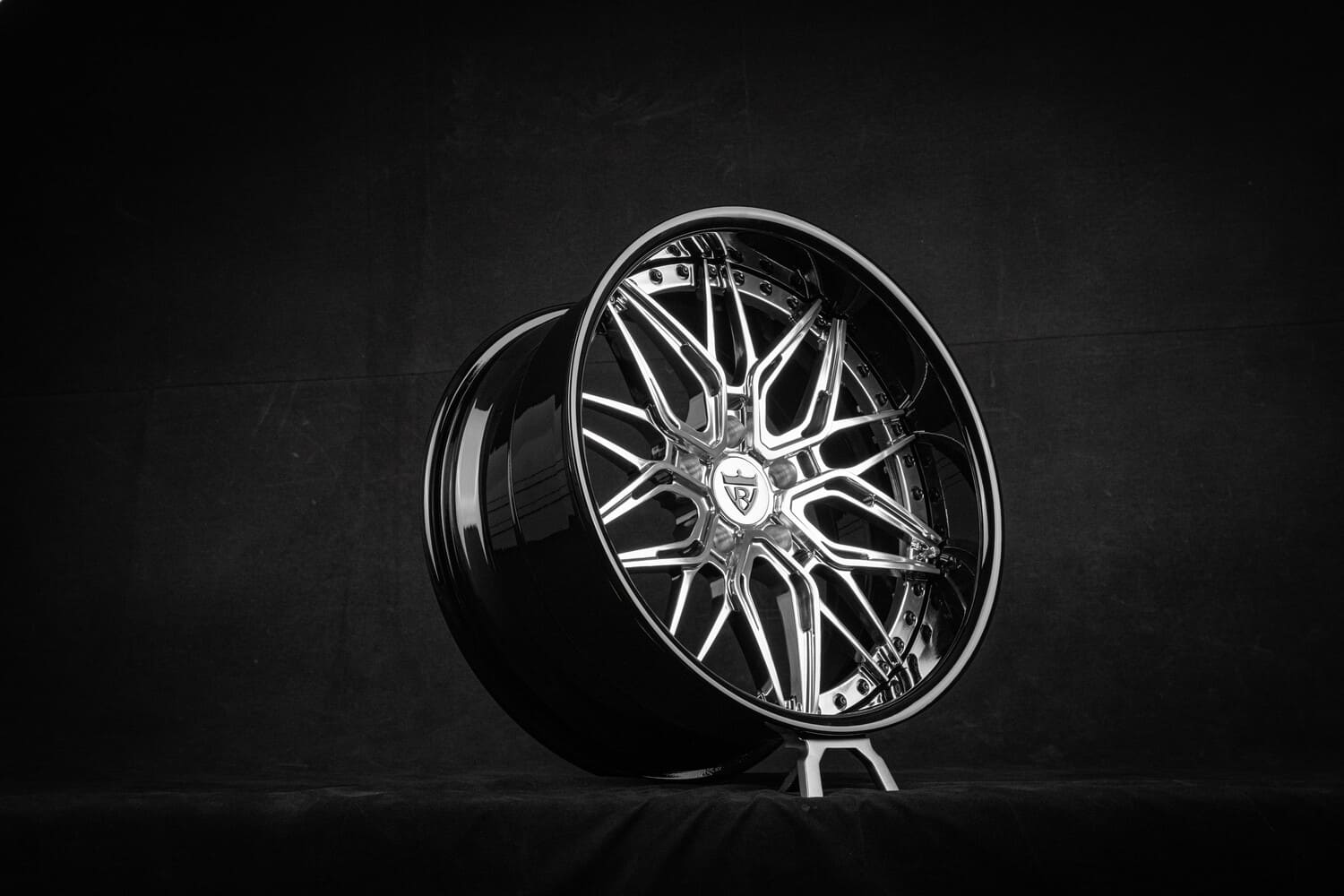 Close-up of polished aluminum spoke with black rivets on custom wheel