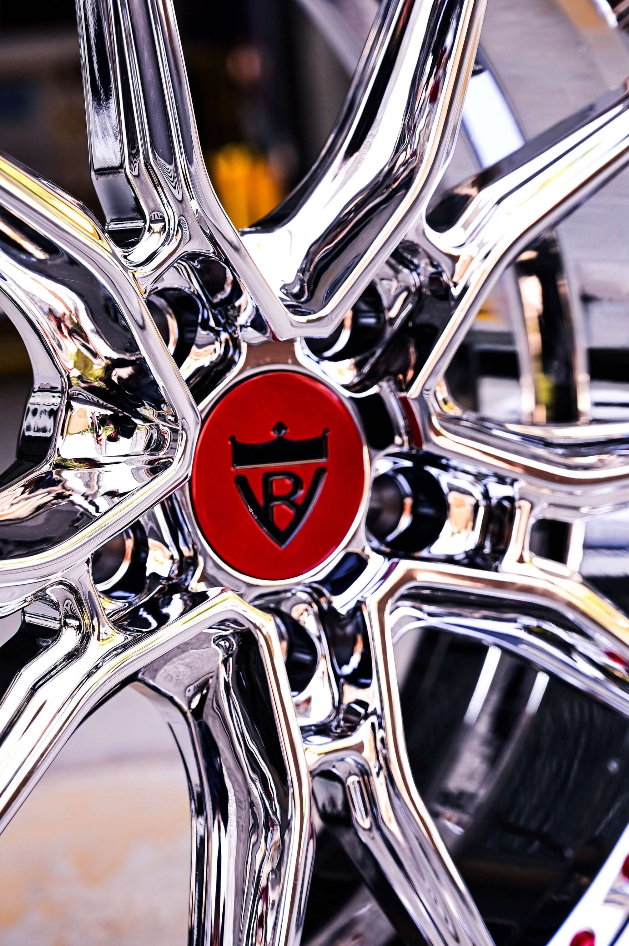 Close-up of chrome wheels designed for C8 Corvette with red logo, showcasing style and performance for 2021 Corvette models.