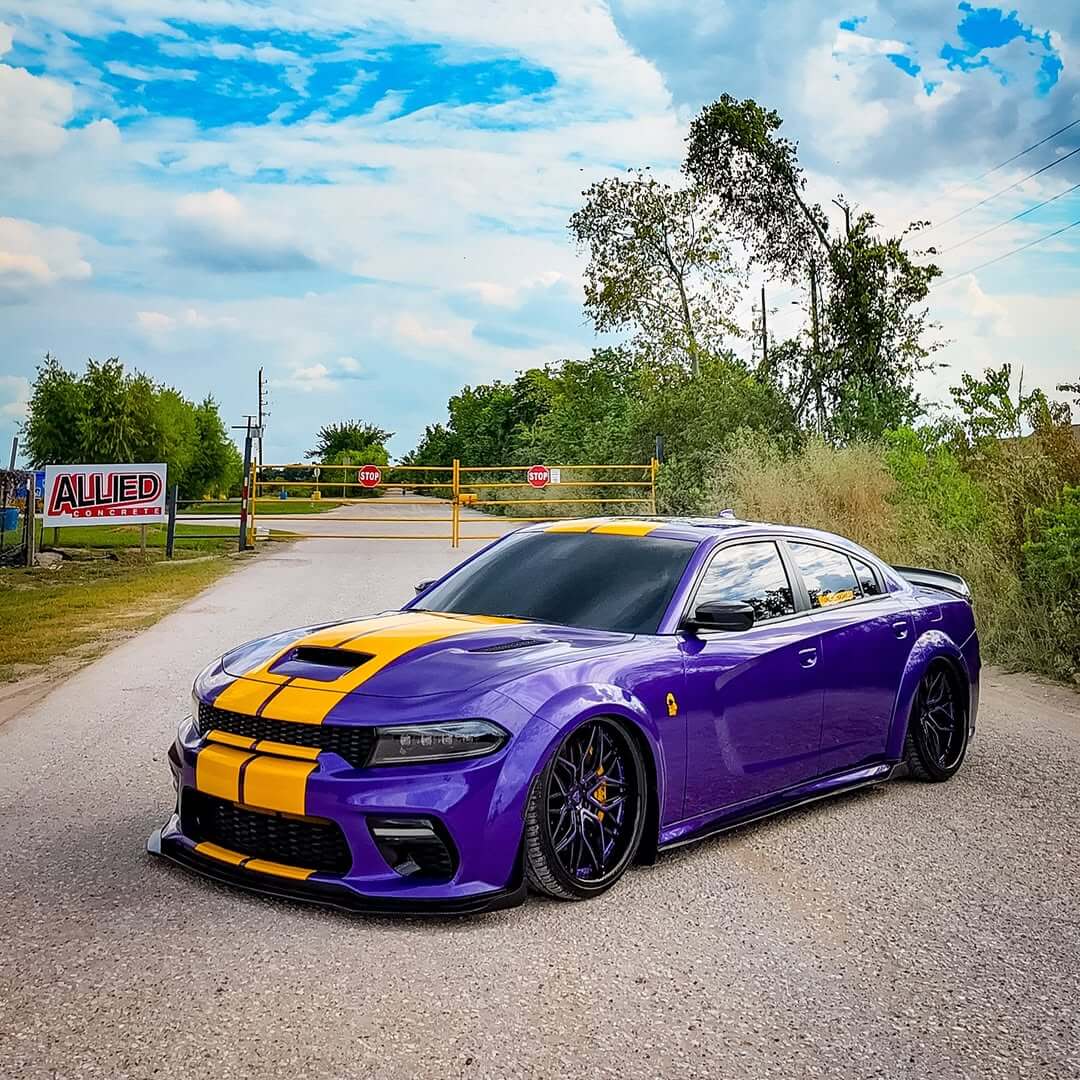 Customized Dodge Charger Widebody in purple with black wheels and deep dish custom forged rims, showcasing a vibrant design.