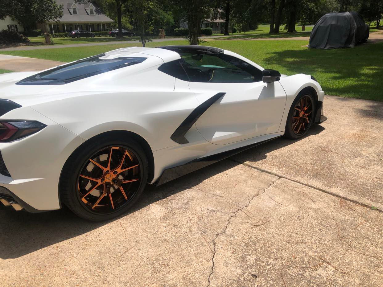 White Corvette C8 showcasing custom forged rims with bronze wheels, emphasizing its sleek design and performance.