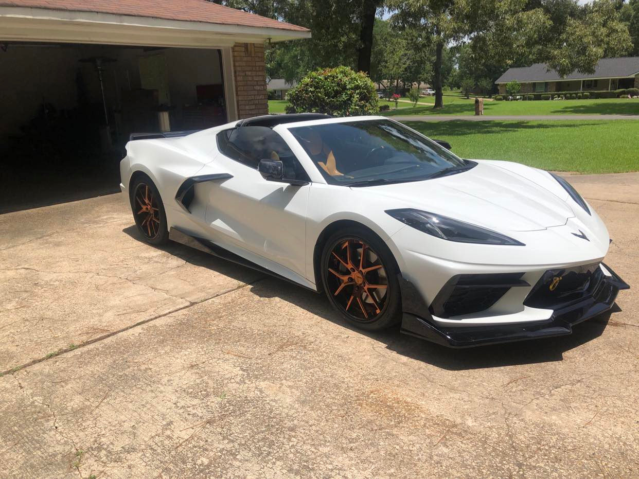 White Corvette C8 showcasing custom forged bronze wheels, highlighting its sleek design and performance features.