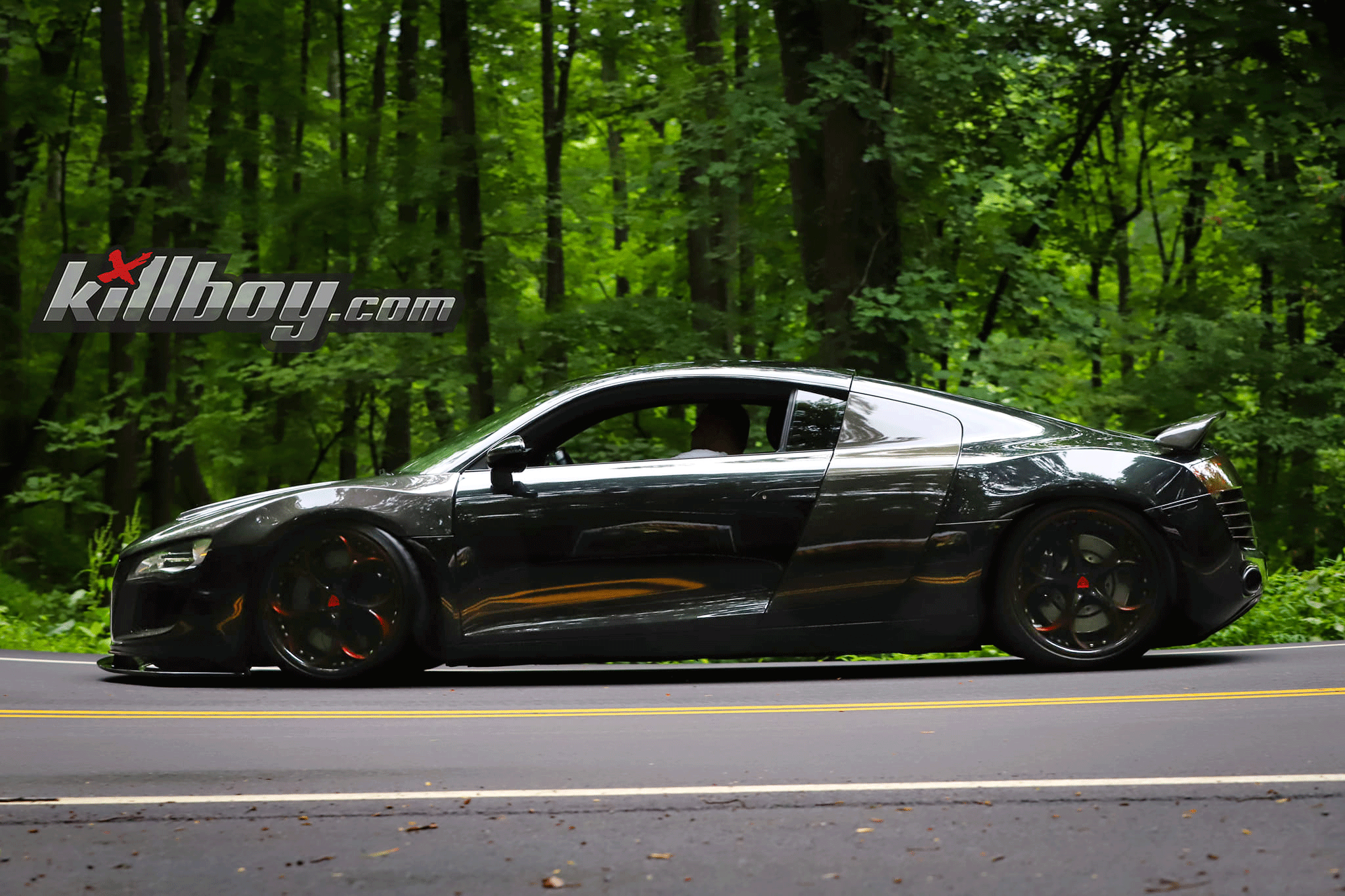 Custom Audi R8 on forest road showcasing aftermarket wheels and sleek design.