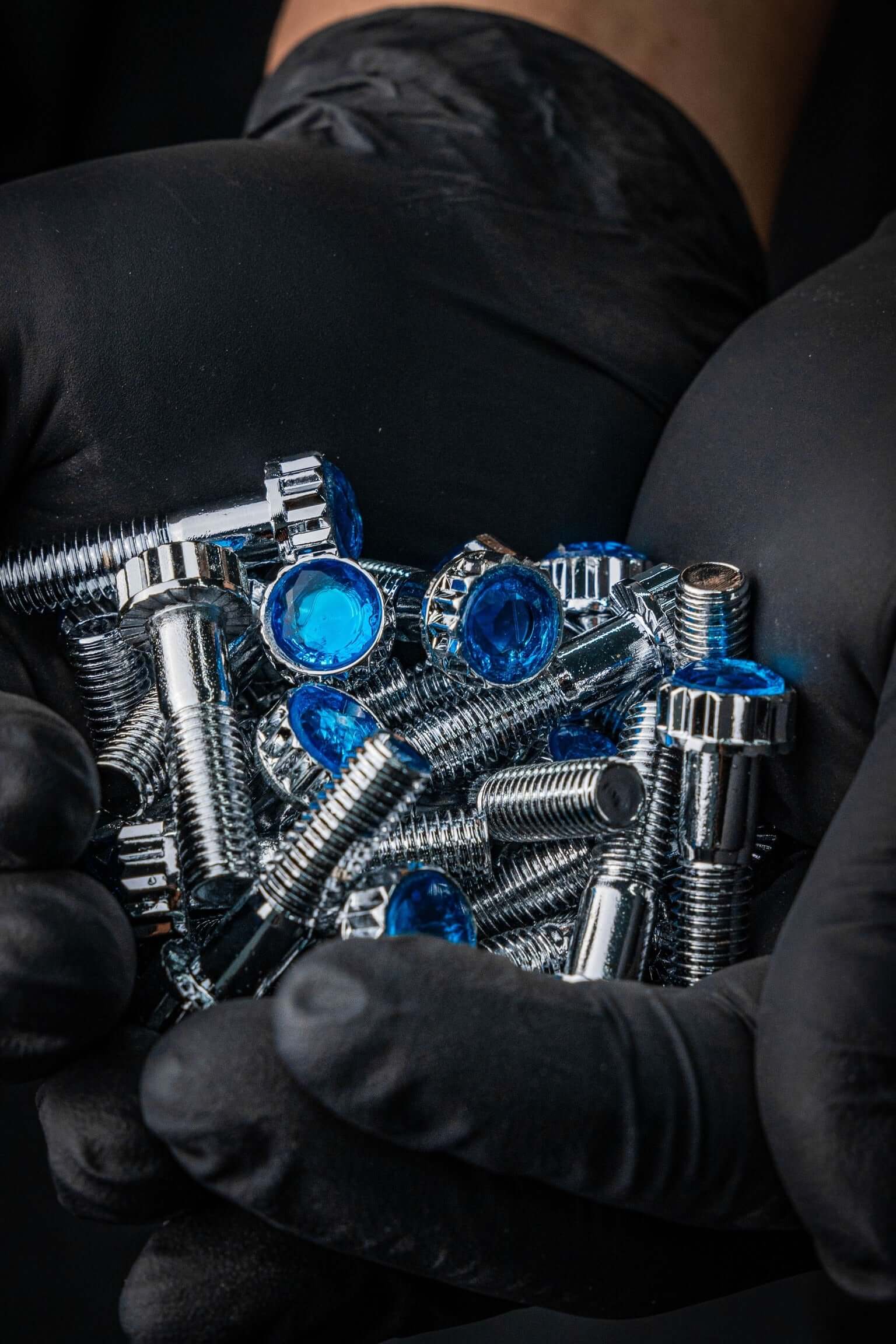 Gloved hands holding Crystal Shiny Screws, ideal for Dodge Dakota R/T wheels and custom 6 lug rims, available in 17 to 26 inches.