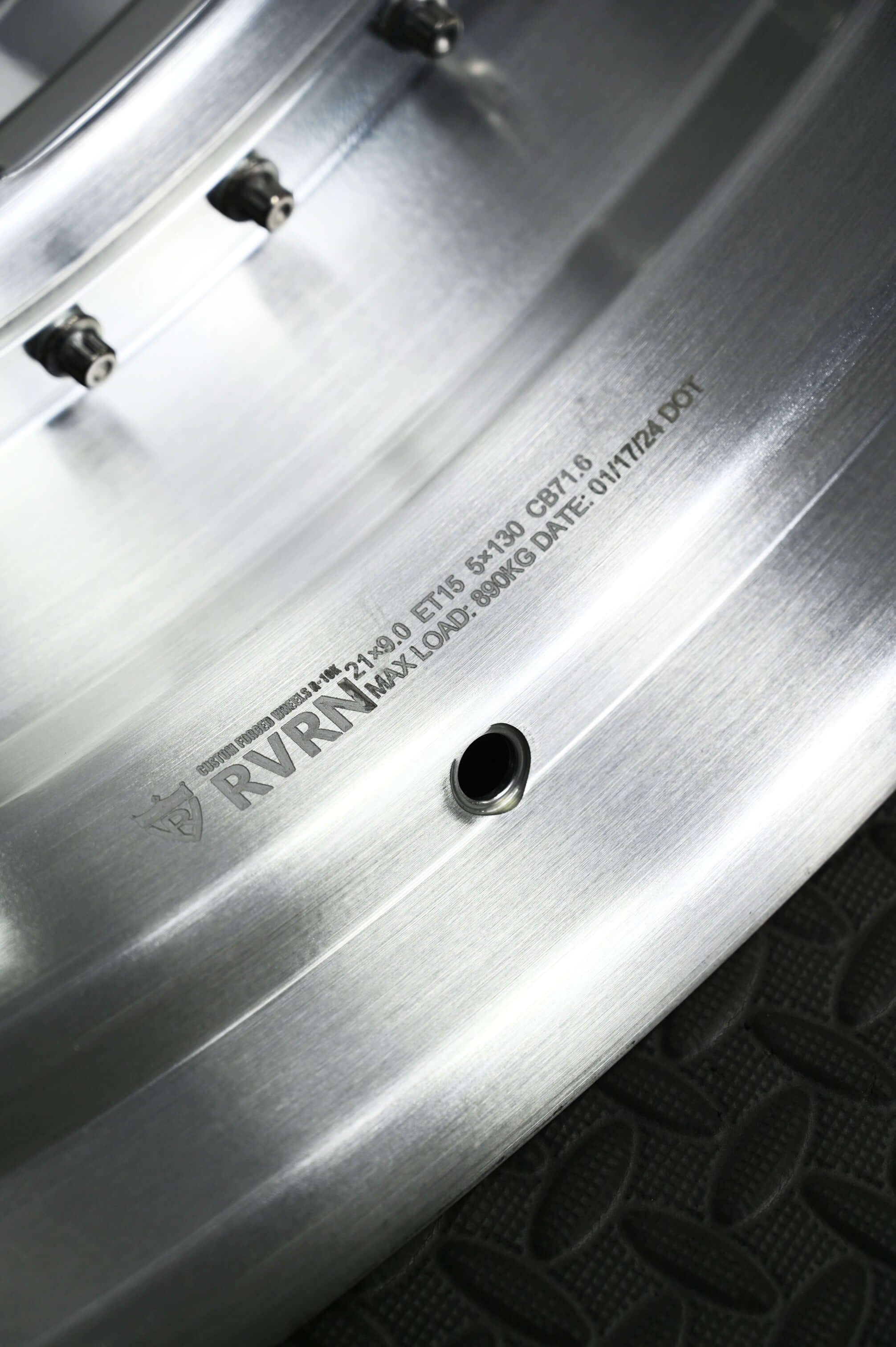Close-up of a forged Porsche Cayman wheel showcasing its deep lip design and detailed manufacturing information.