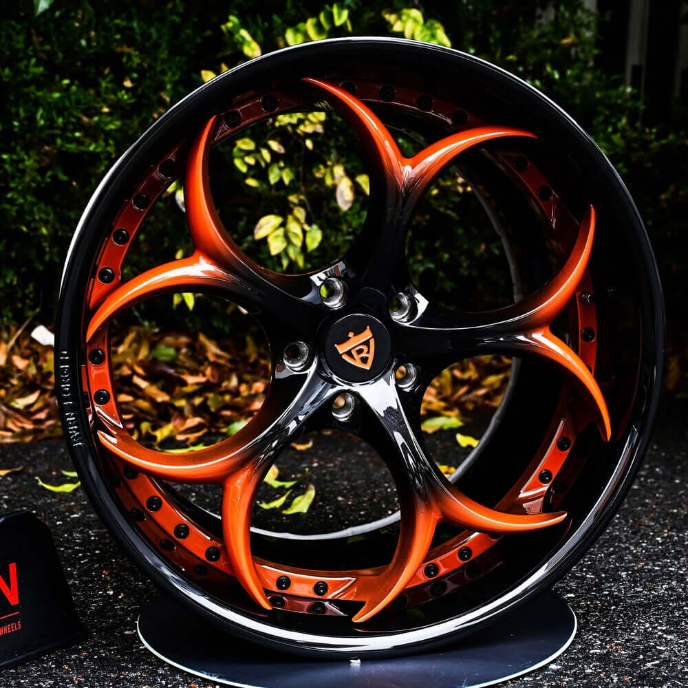 Custom 2-piece forged wheel in black and orange design, showcasing intricate spoke pattern and high-quality craftsmanship.