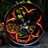 Custom 2-piece forged wheel in black and orange design, showcasing intricate spoke pattern and high-quality craftsmanship.