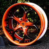Custom orange and black forged wheel designed for performance vehicles, showcasing a unique stylish design and precision engineering.