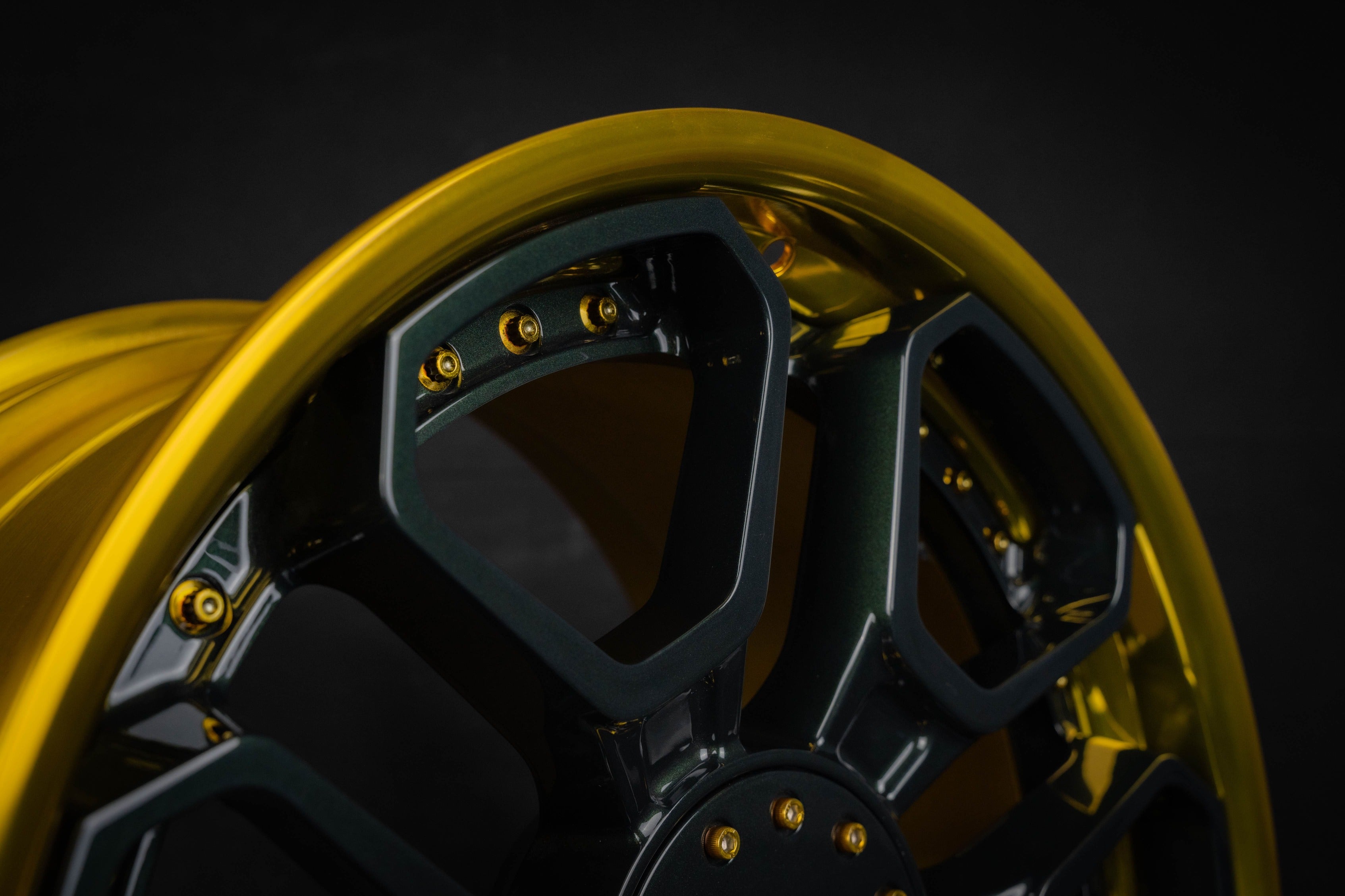 Close-up of stylish Dakota RT 6 lug wheel for Dodge Dakota with a gold and black finish on a dark background