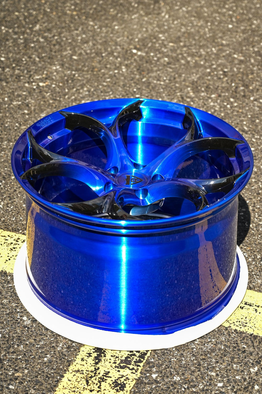 Blue forged Corvette C7 custom rim displayed outdoors, highlighting its sleek design and vibrant color.