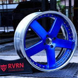 Custom blue 2-piece forged 5-spoke chrome wheel RV-DF93 displayed with RVRN logo in an automotive garage.