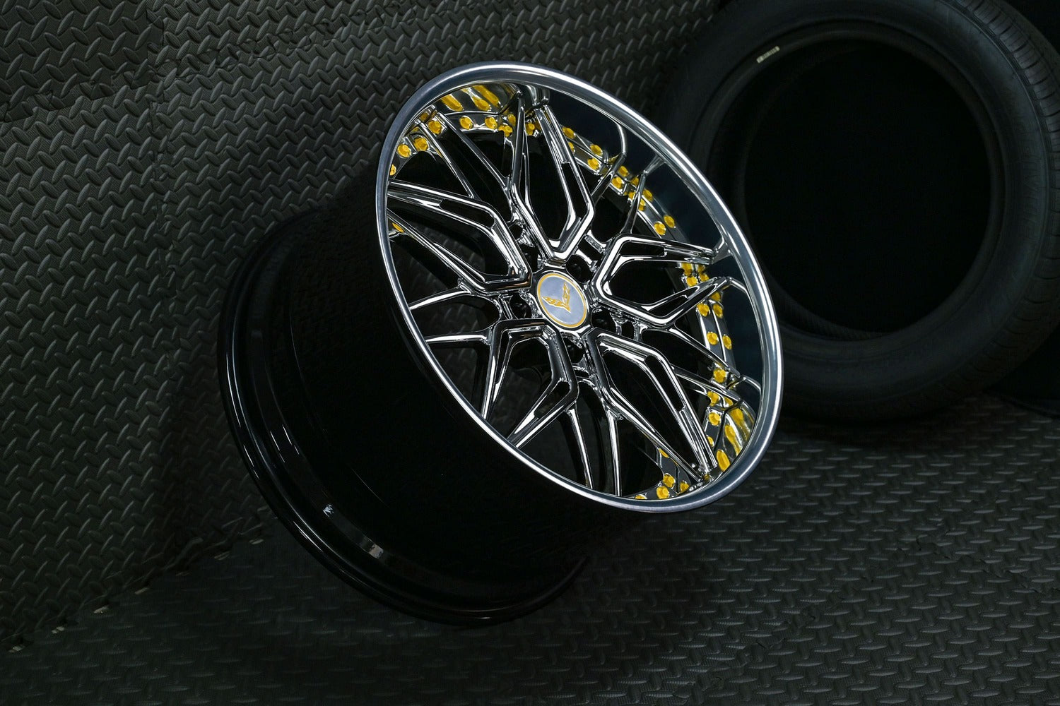 Chrome Corvette C7 deep dish wheel with intricate design displayed on diamond-plate floor, highlighting its stylish appeal.