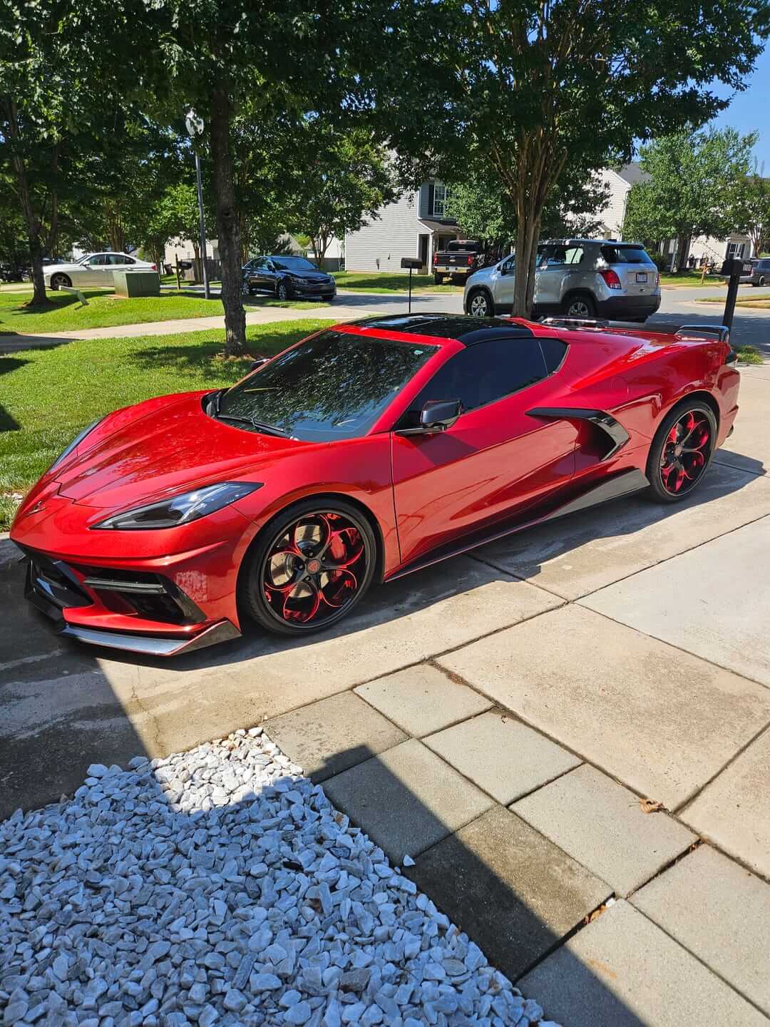 Red Corvette C8 featuring sleek custom RVRN Forged Wheels in a residential setting.