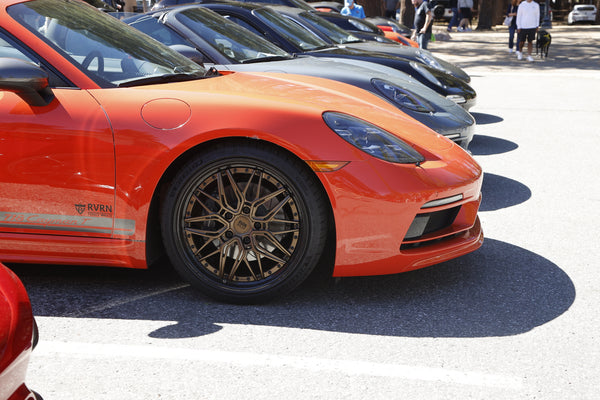 Close-up of RVRN custom forged wheel showcased during Porsche event.