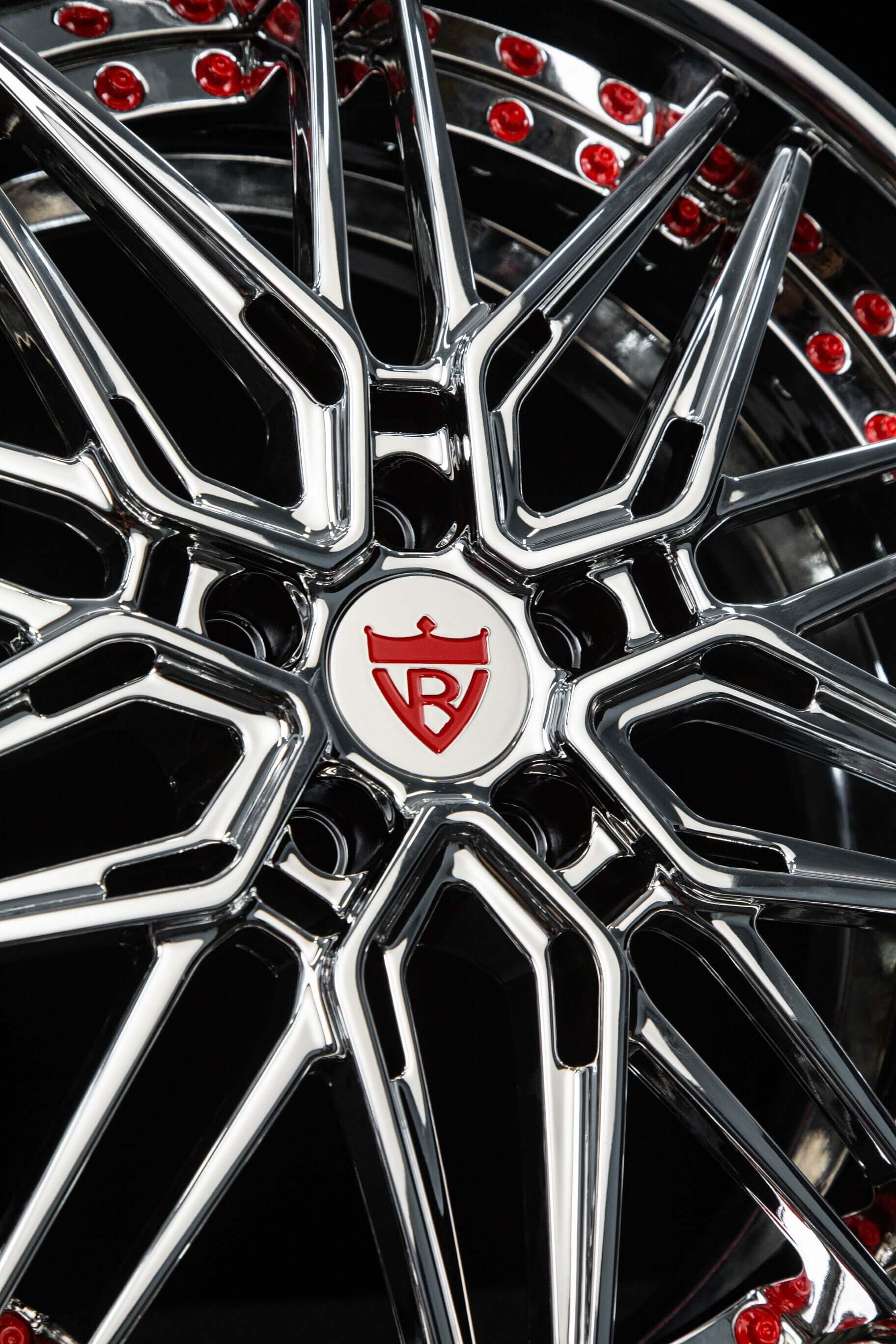 Close-up of chrome aftermarket staggered wheels for C5 Corvette, featuring intricate design and red accents.