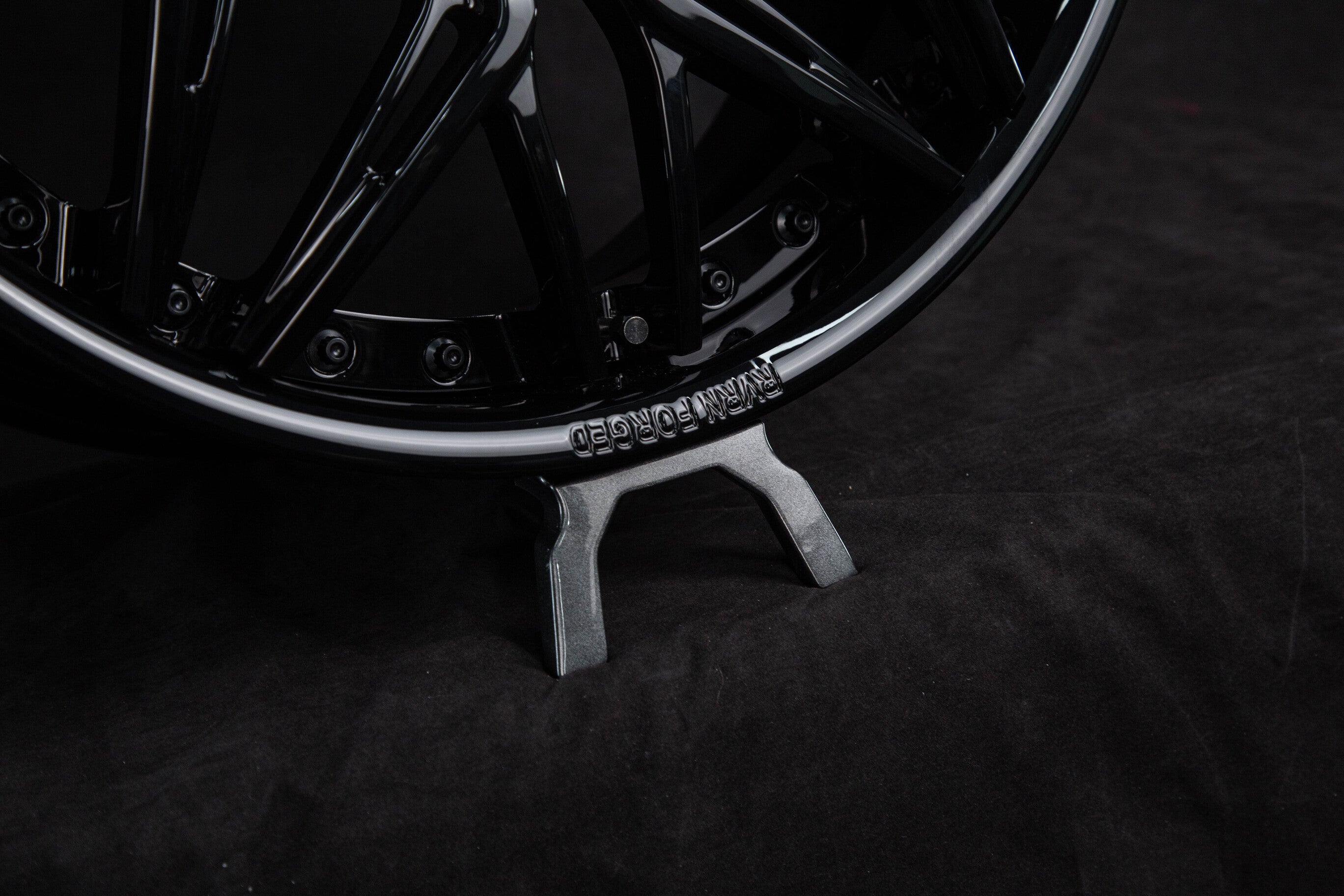 Close-up of black C8 Corvette custom wheels showcasing deep dish design and sleek finish on a dark background.
