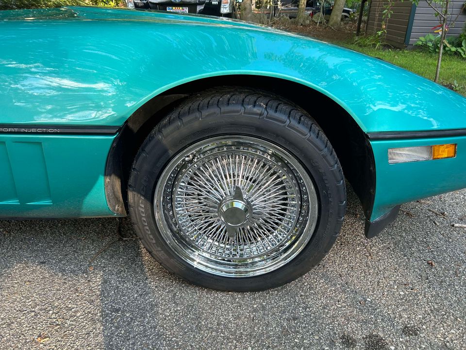 C4 Corvette featuring custom wire wheels, showcasing a bright turquoise body and 17-inch wheel size.
