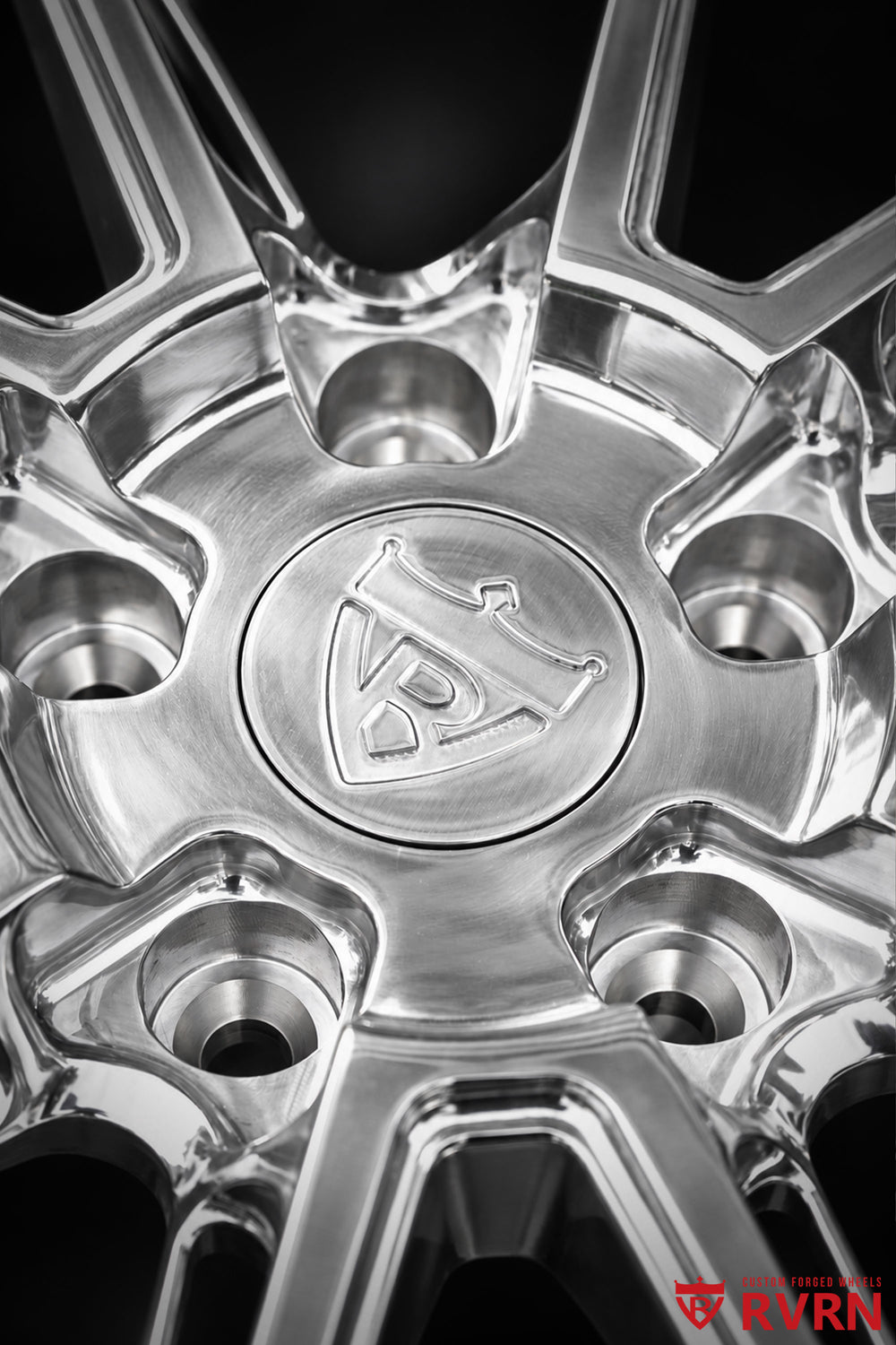 Detailed center view of the RVRN RV-DC26 multi-spoke forged wheel for a 2009 Corvette C6 Base, highlighting the polished center area, lug holes, RVRN center cap, and precise machined spoke intersections.