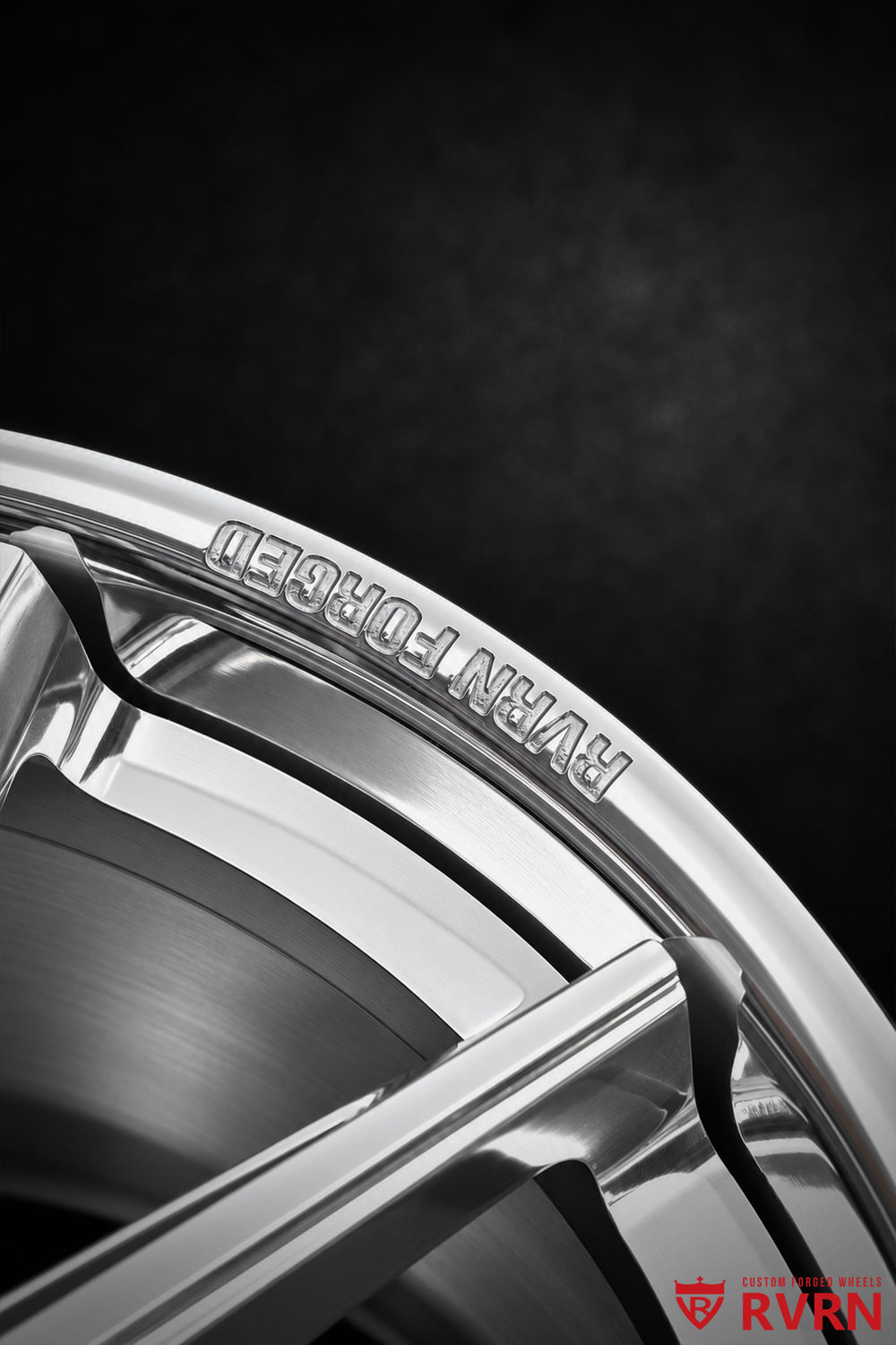 Detailed RVRN RV-DC26 wheel rim engraving and outer barrel view for a 2009 Corvette C6 Base, showing the polished rim edge, RVRN FORGED lettering, recessed barrel area, and multi-spoke transition.