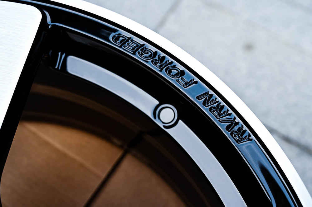 Close-up of the RVRN FORGED engraving on the gloss black outer lip of the RV-MP223 wheel for a 2011 Chevy Camaro LT.
