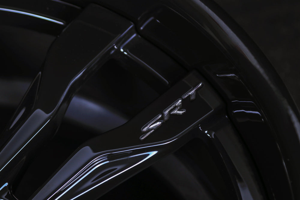 Macro detail of custom CNC-engraved SRT logo on Gloss Black spoke of RVRN RV-DR88 2-piece forged wheel.
