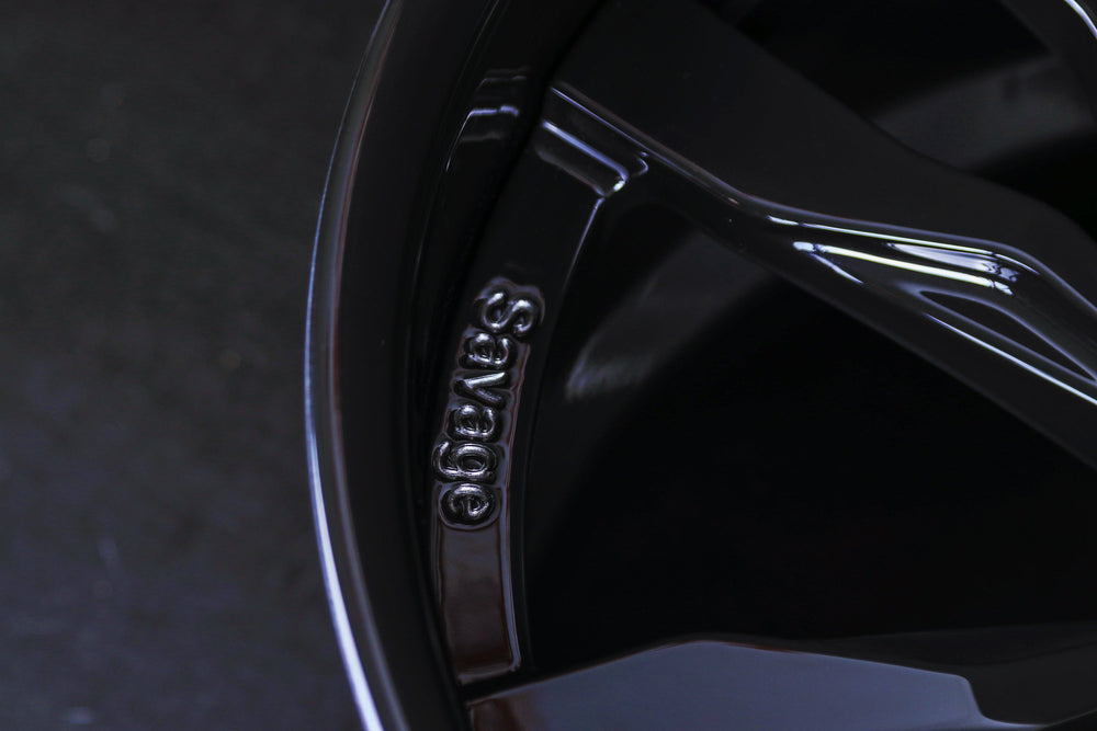 Close-up view of bespoke Savage engraving on Gloss Black forged spoke of 20x11 RV-DR88 wheel.