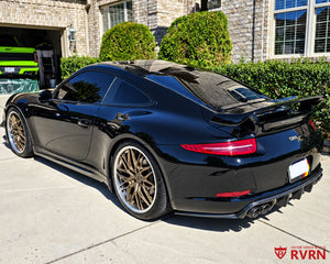 Rear three-quarter view of a 2012 Porsche 911 Carrera S with matte bronze RVRN RV-T081 forged wheels and polished barrel.