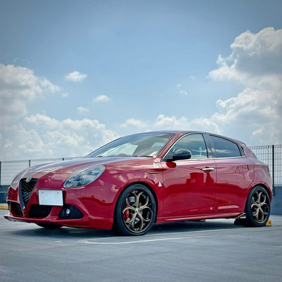 Custom Alfa Romeo with bronze custom rims showcasing stylish forged wheels against a clear blue sky.