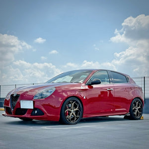 2013 Alfa Romeo Giulietta on RVRN RV-DS016 custom forged wheels in matte bronze and gloss black, front three-quarter view under open sky.