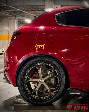 Rear RVRN RV-DS016 forged wheel on a red 2013 Alfa Romeo Giulietta, matte bronze spokes and gloss black barrel with exposed bolts, in a garage.