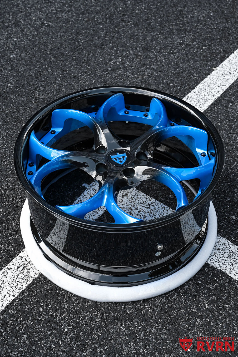 2015 Corvette C7 Z51 RV-DS016 forged 2-piece wheel photographed outdoors from an elevated three-quarter angle, showing the blue gradient spokes, Gloss Black Barrel, black center area, and deep wheel profile