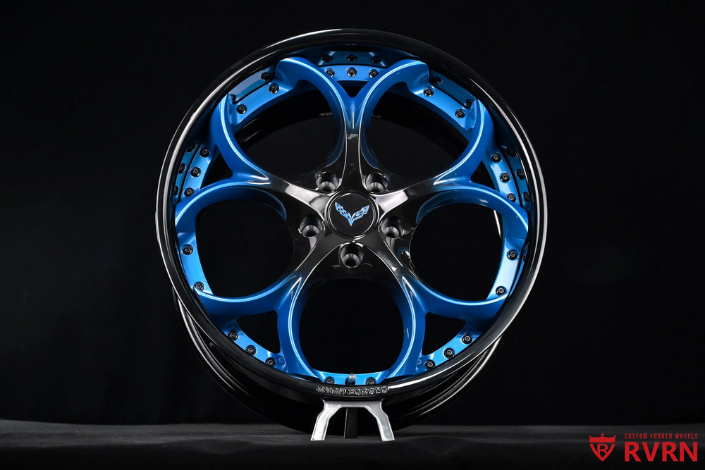 Front-facing studio view of a 2015 Corvette C7 Z51 RV-DS016 forged 2-piece wheel, clearly showing the blue gradient spokes, black spoke sections, Gloss Black Barrel., lug holes, and outer hardware ring