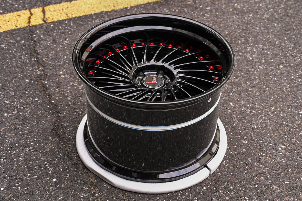 Gloss black multi-spoke RVRN RV-DN01 forged wheel standing on the shop apron, custom wheels for the 2016 Corvette C7 Base Widebody