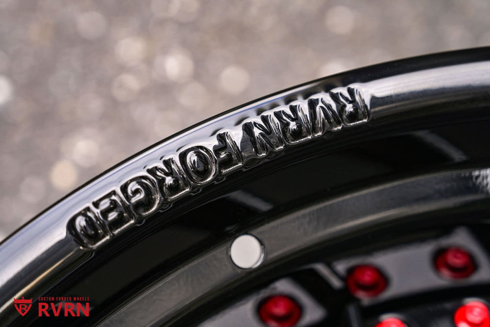 Close-up of the RVRN FORGED engraving and red rim screws on a Gloss Black RVRN RV-DN01 forged wheel