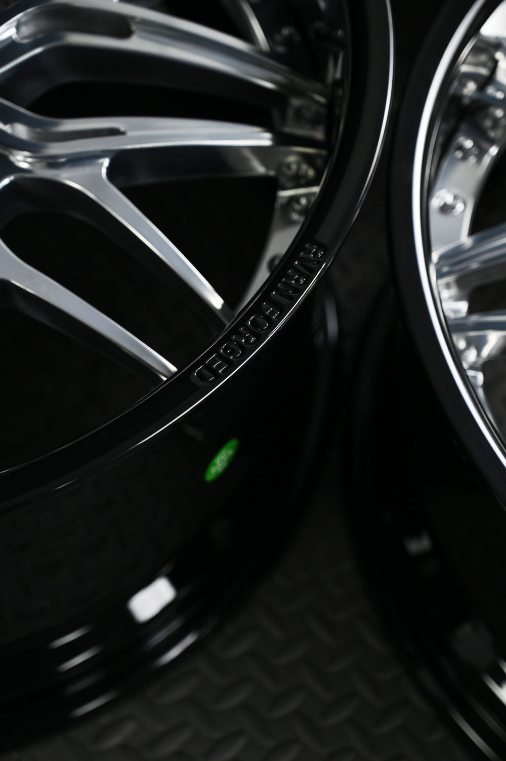 Close-up of the RVRN RV-T081 deep dish lip and two-piece hardware, polished spoke edges against a glossy black barrel.