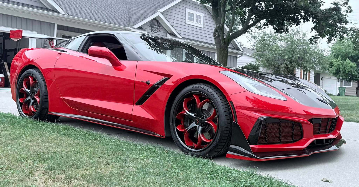 Front view of a red 2017 Corvette C7 Z51 on RVRN RV-DS016 forged wheels with red and black spokes outside a suburban home