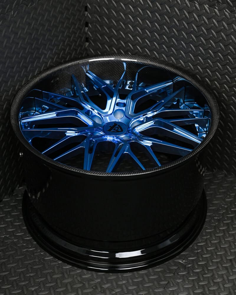 Front quarter view highlighting blue forged wheel design
