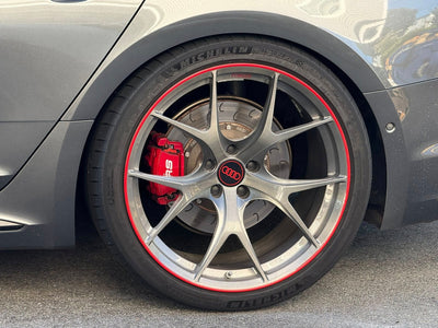 Close-up of Audi RS5 with custom lightweight RVRN wheels featuring red accents and performance brake calipers.