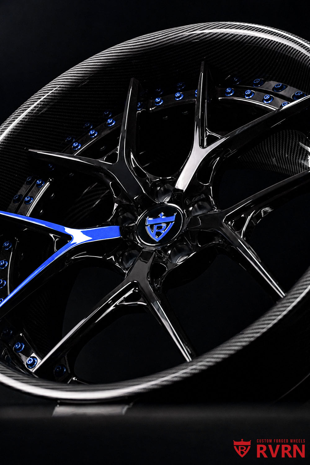Close-up of Challenger black and blue wheels featuring RVRN RV-DR08D Y-spoke forged construction and a single blue spoke accent