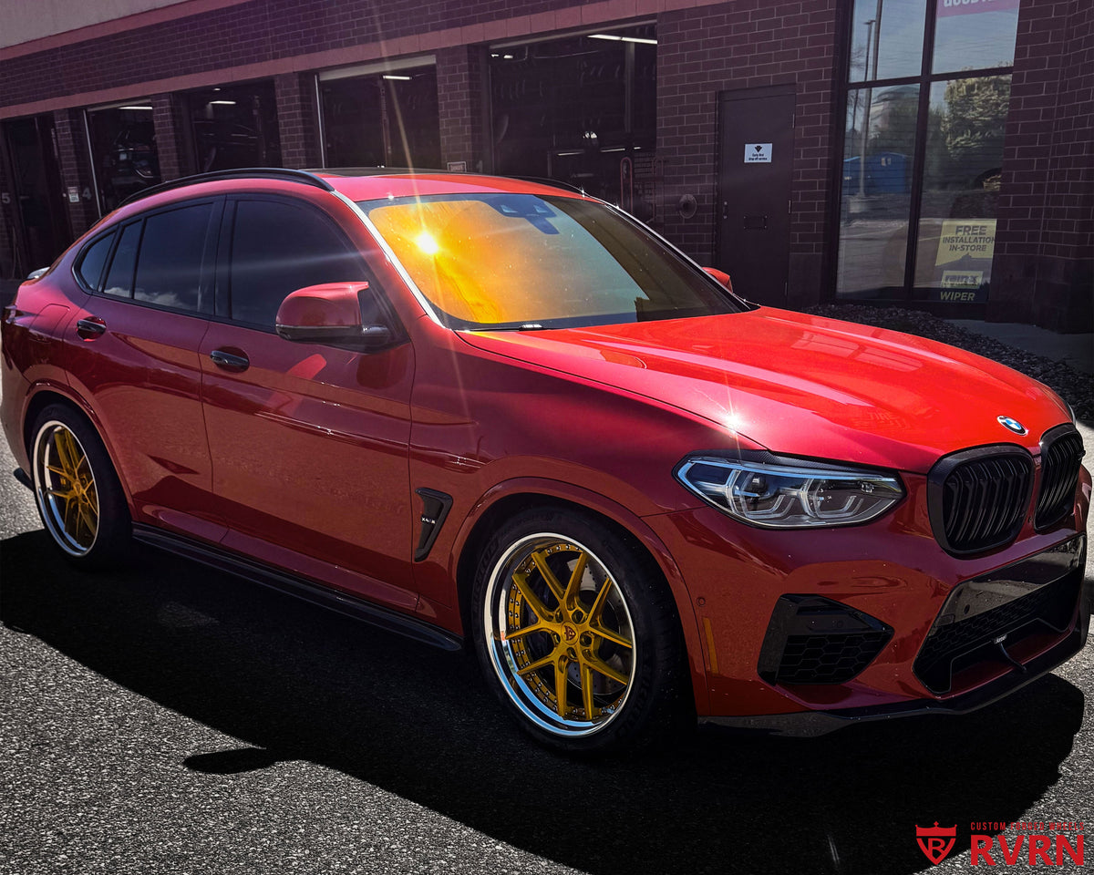 2020 BMW X4M Competition on RVRN RV-DR08D 2-piece custom forged wheels in Brushed Dark Gold Spoke with Gloss Black Barrel and Polished Lip, front view at the tire shop with Michelin Pilot Sport 4S tires.