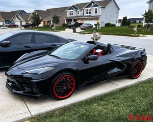 2021 Corvette C8 Stingray convertible on RVRN RV-DC01 gloss black and red forged wheels, front three-quarter view with the top down.