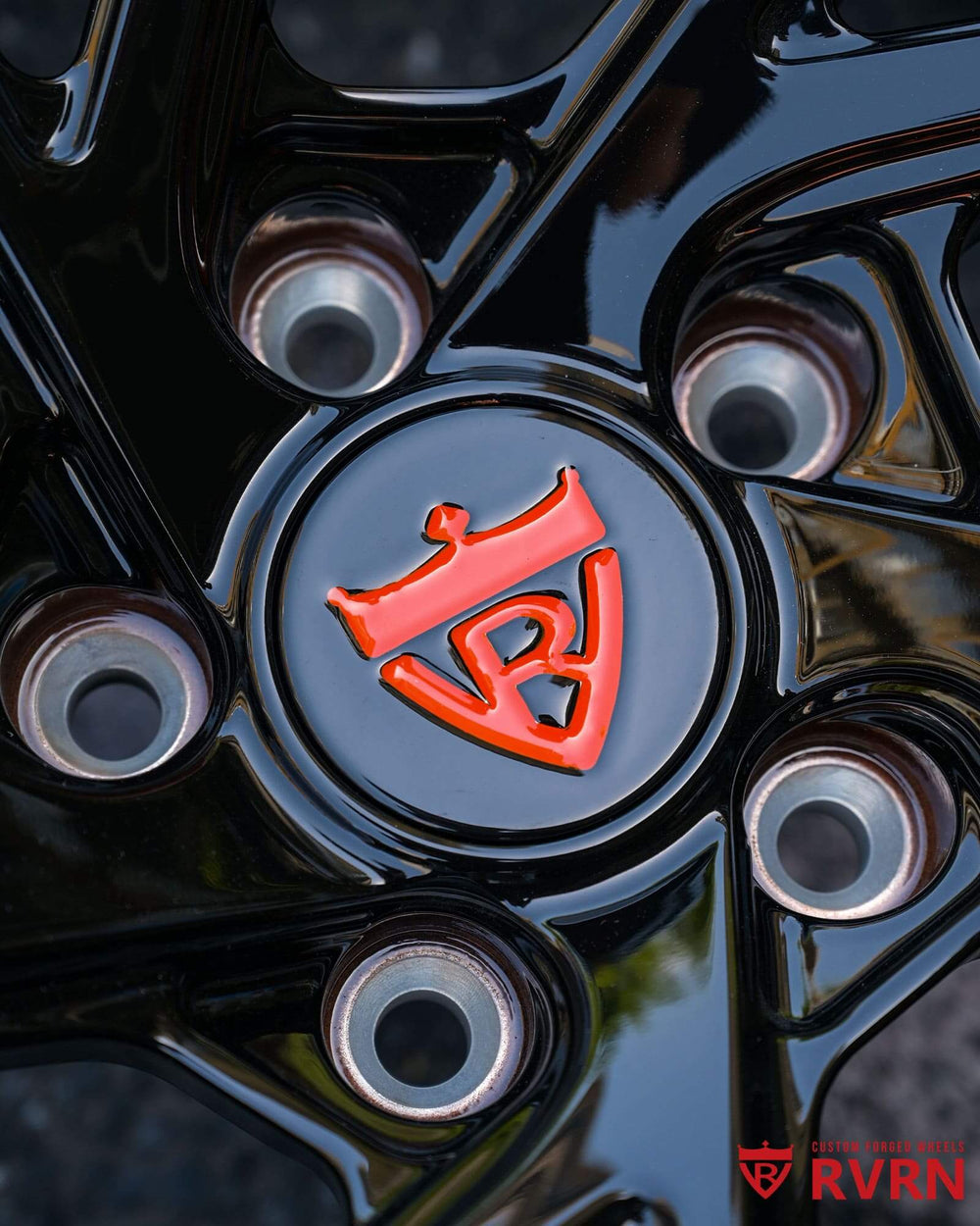 Close-up of black custom wheel rim with orange logo, perfect for C8 Corvette and Sebring orange styling.