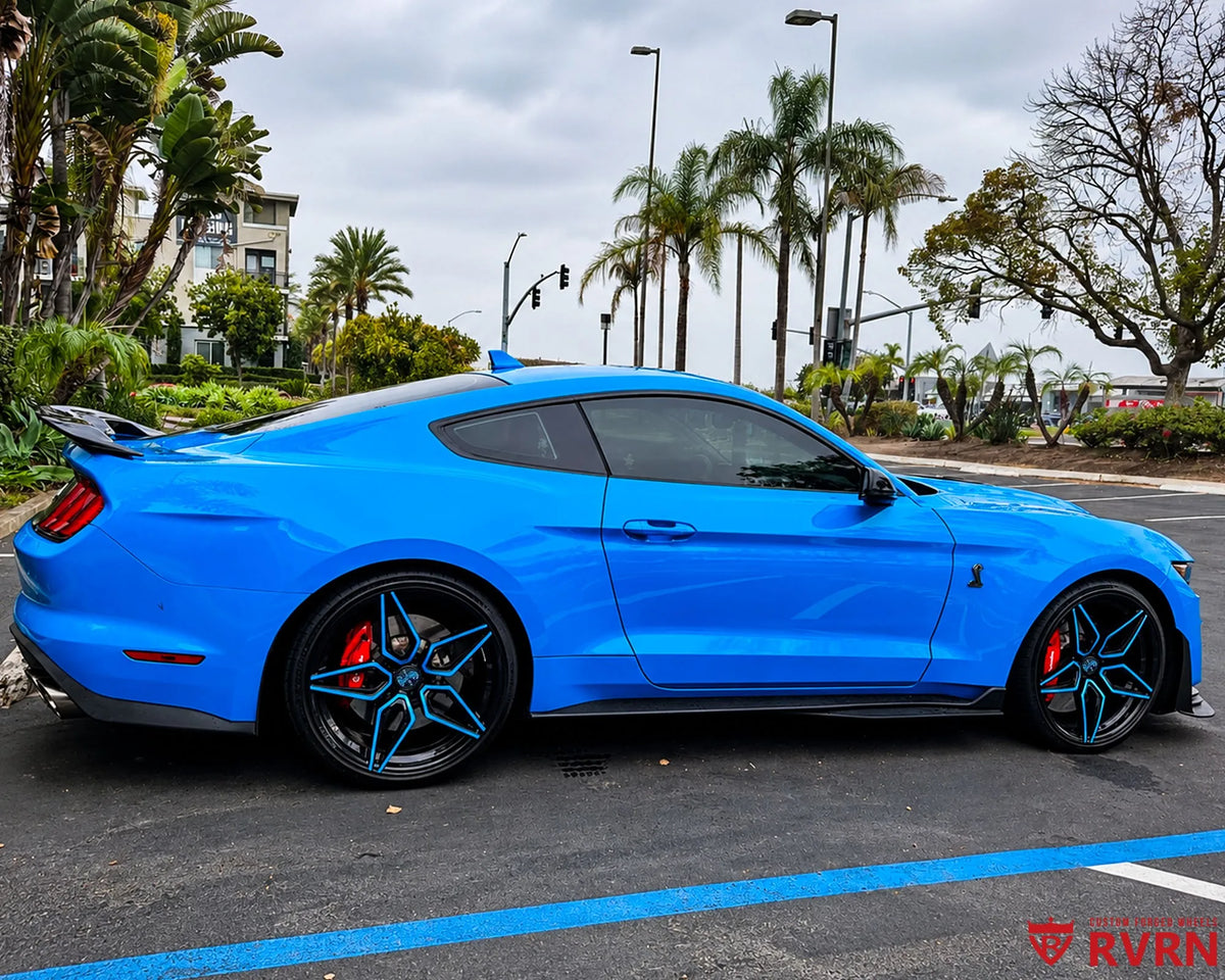 2022 Ford Mustang GT500 on RVRN RV-MC07 1-piece forged wheels in gloss black with rapid blue spoke accents, side view.