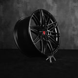 Black custom forged monoblock rim designed for Tesla Model Y, featuring a sleek staggered 21-inch performance design.