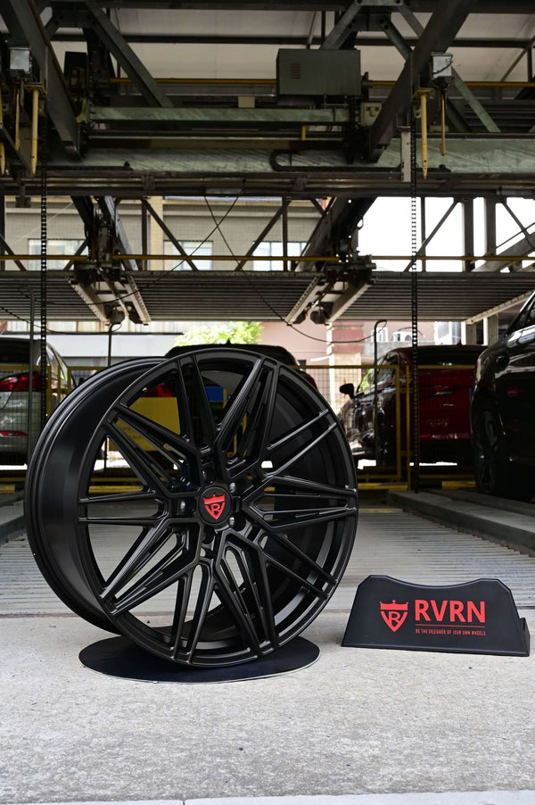 Black custom forged monoblock rim displayed in a parking garage, featuring RVRN branding. Ideal for Tesla Model Y performance.