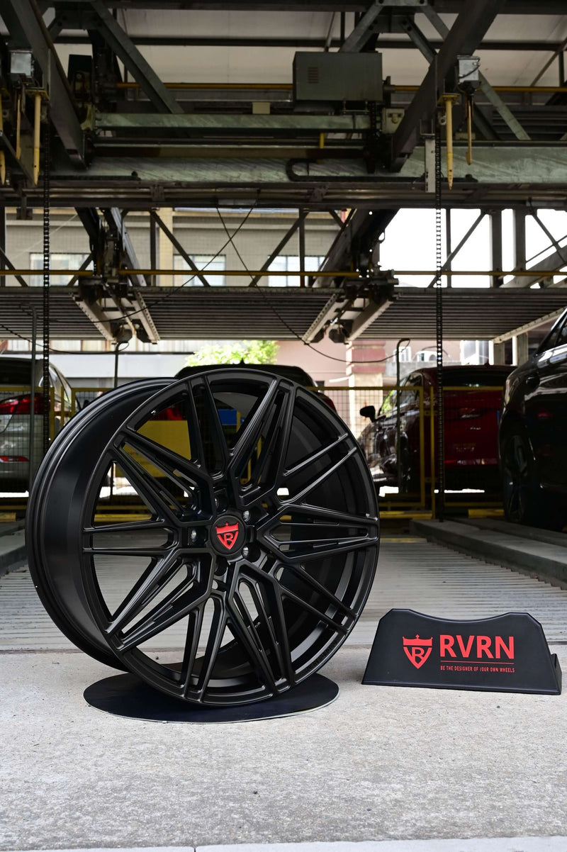 Black custom forged monoblock rim displayed in a parking garage, featuring RVRN branding. Ideal for Tesla Model Y performance.