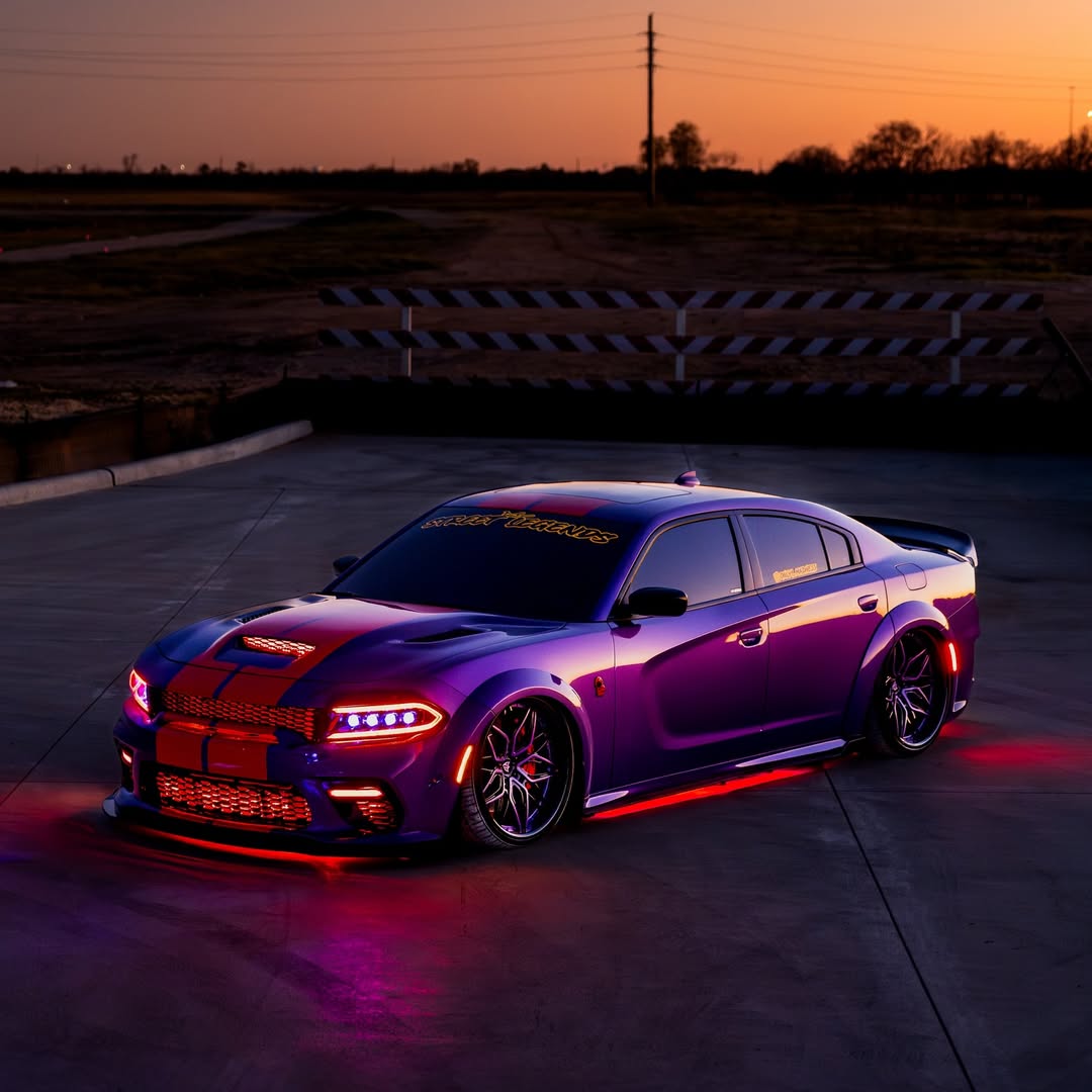 Dodge Charger with 22-inch deep dish purple and black custom forged wheels, illuminated under sunset.