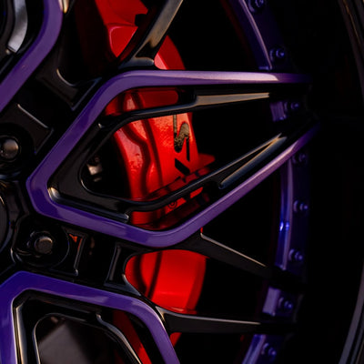 Close-up of RVRN custom forged 22-inch deep dish rims in purple and black, showcasing brake caliper detail.