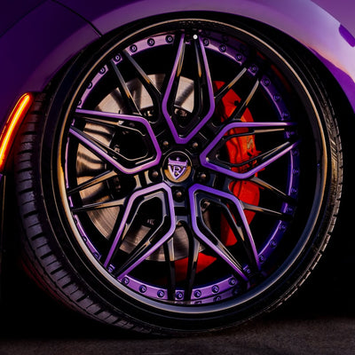 Close-up of purple and black RVRN custom forged 22-inch deep dish rims on a Dodge Charger.