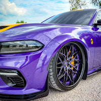 Dodge Charger Widebody with custom forged purple and black deep dish rims showcased against a scenic backdrop.