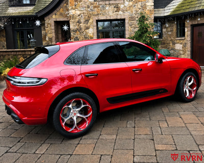 2024 Porsche Macan GTS on RVRN RV-MS016 custom forged wheels with Carmine Red barrel, rear three-quarter view in front of the stone house during the holiday season.